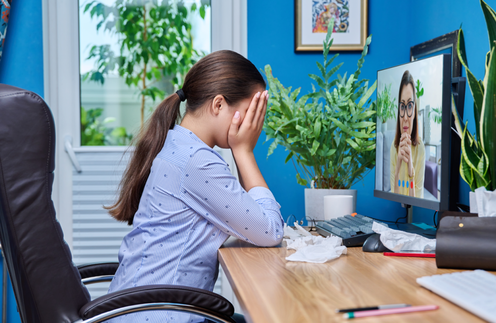Frustrated remote worker under micromanagement pressure during a video call