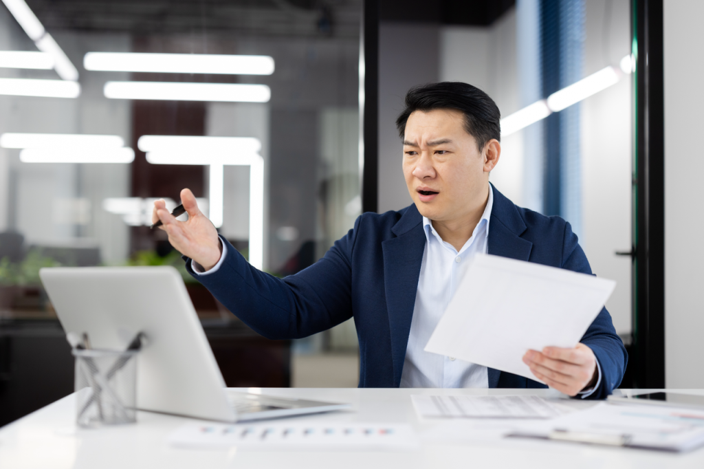 Manager reviewing remote task progress dashboard with skeptical expression